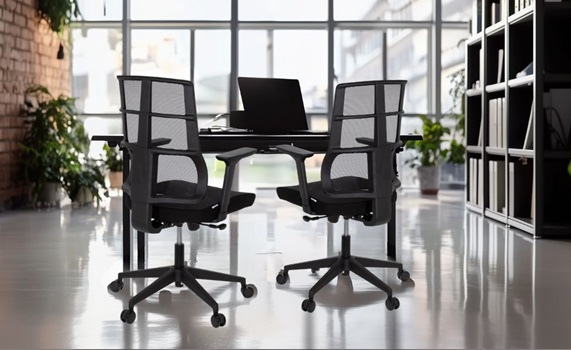 Zwei schwarze Bürostühle stehen in einem modernen Büro im Industrial-Design Zwei schwarze Bürostühle stehen in einem modernen Büro im Industrial-Design